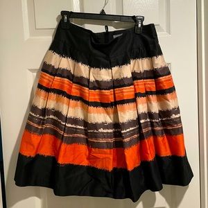 Women’s pleated skirt in black and shades of coral. Size 12 from H&M